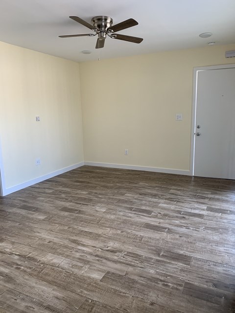 A room with a ceiling fan and a closed door.