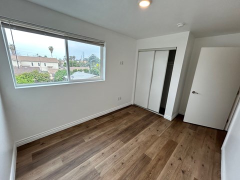 A room with a window overlooking a residential area.