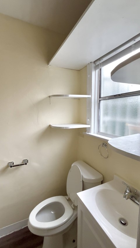 A white toilet and sink in a small bathroom.