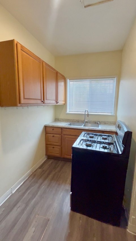 A kitchen with wooden cabinets and a black stove top oven.