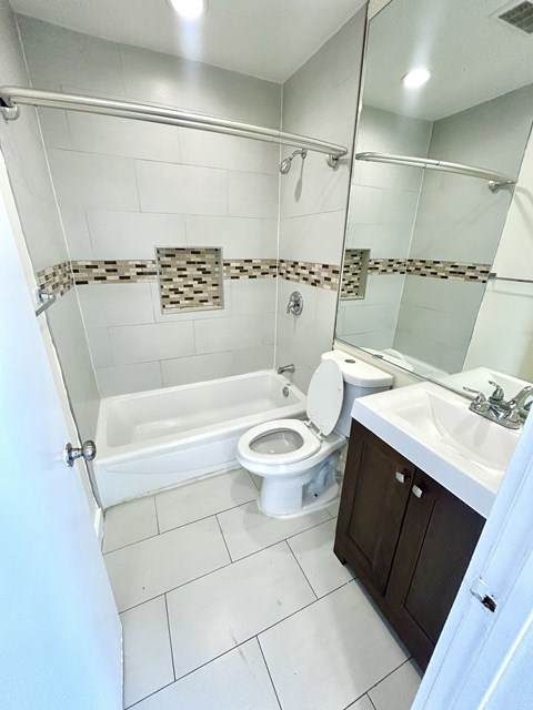 A white bathroom with a toilet, sink, and bathtub.