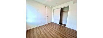 A room with a white door and a wooden floor.