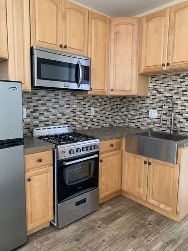 A kitchen with wooden cabinets and a black and white checkered backsplash.