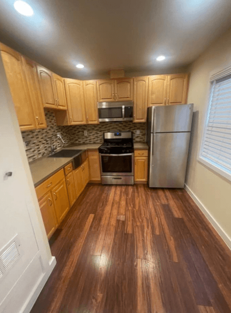 A kitchen with wooden cabinets and a refrigerator.