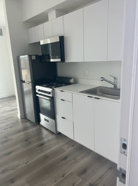 a kitchen with a stove a sink and a microwave