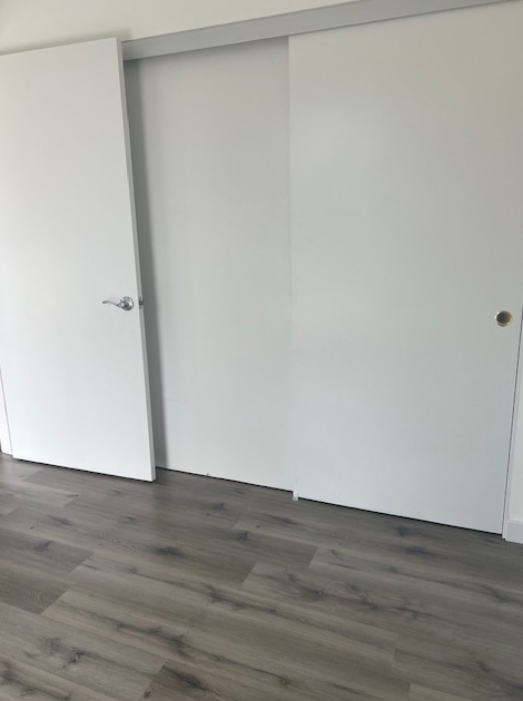 an empty room with white walls and a wooden floor