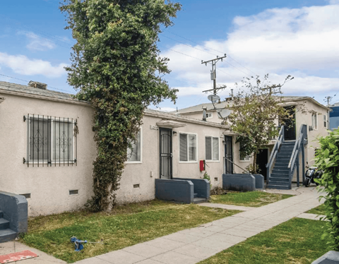 A row of houses with a tree in front of the first one.