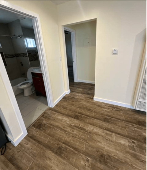 a bathroom with a wooden floor and a toilet