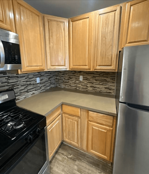 A kitchen with wooden cabinets and a black stove top.
