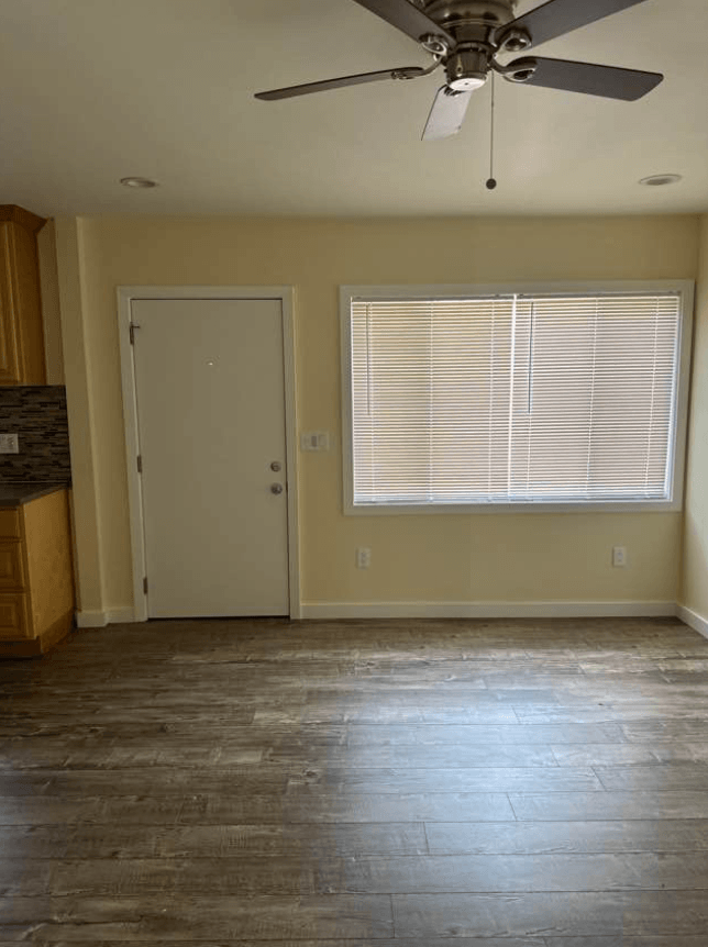 an empty room with a ceiling fan and a window