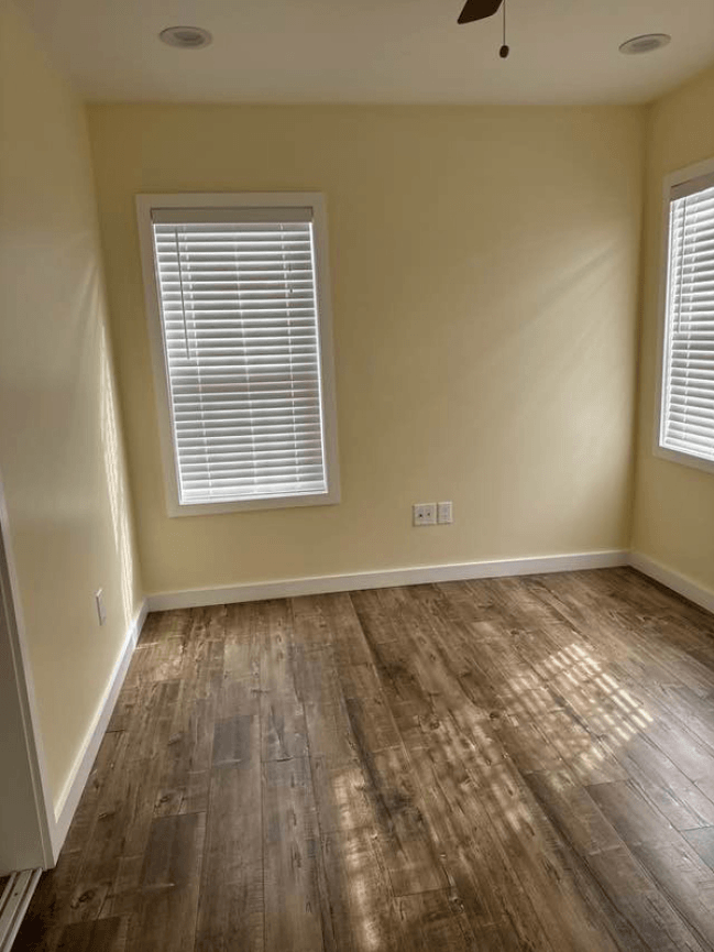 a empty room with wood floors and a window