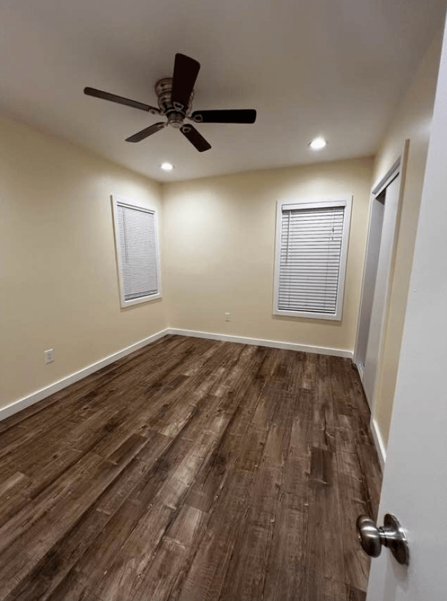 a living room with a ceiling fan and a hard wood floor