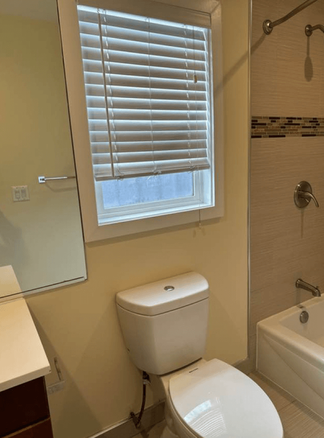 a bathroom with a toilet and a window and a sink