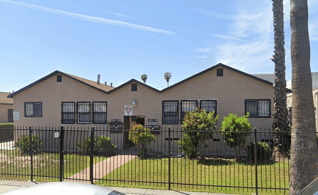 a house with a fence and a gate in front of it