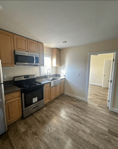 A kitchen with wooden cabinets and a black stove top oven.