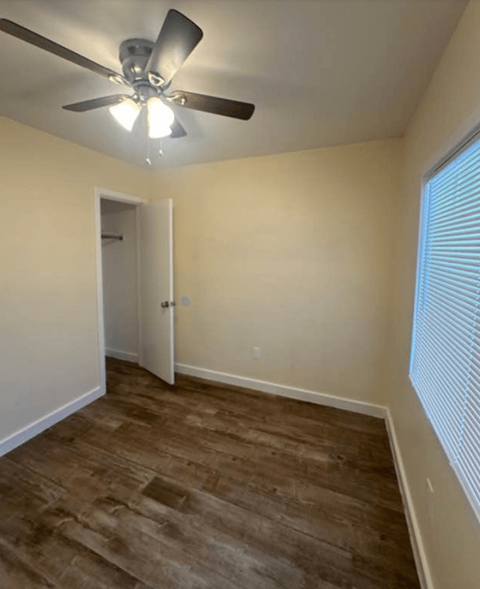 A room with a ceiling fan and a door.