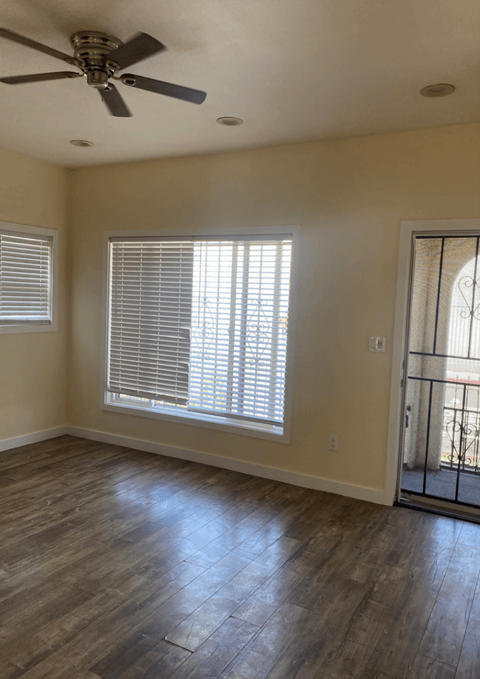 a living room with a large window and a ceiling fan