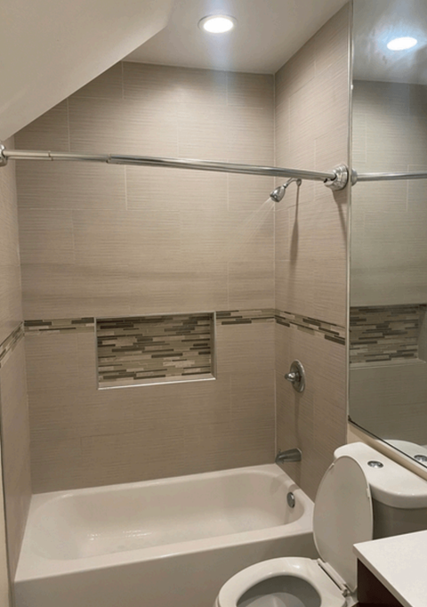 a bathroom with a shower and a toilet and a sink