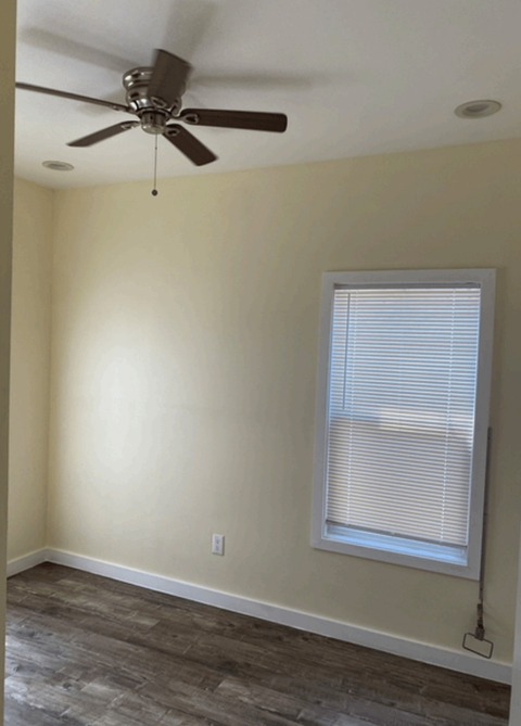 a living room with a ceiling fan and a window