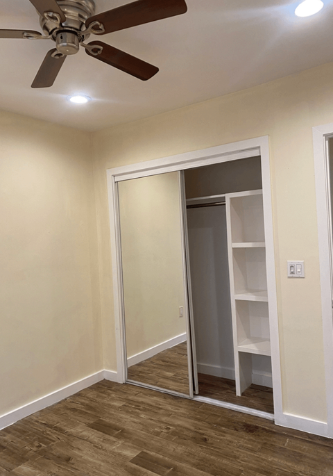 a room with a closet and a ceiling fan