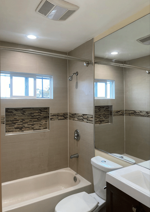 a bathroom with a shower and a toilet and a sink