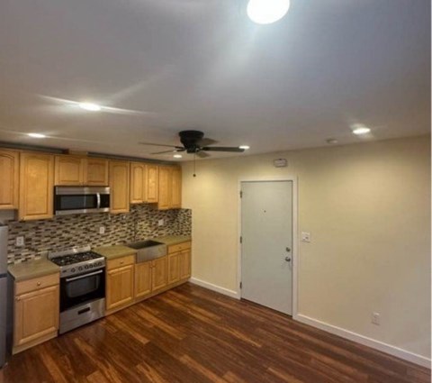 A kitchen with wooden cabinets and a stove top oven.