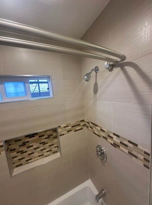 A bathroom with a shower and a window.