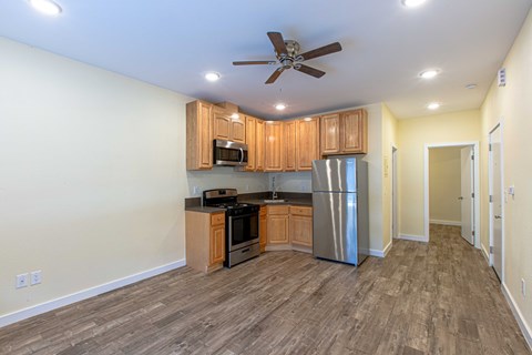 A kitchen with wooden cabinets and a stainless steel refrigerator.