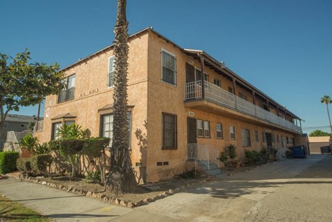 A building with a balcony and a tree in front of it.