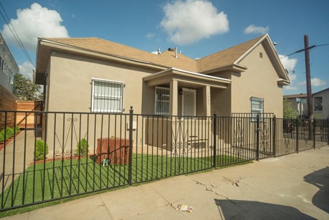 A house with a black fence in front of it.
