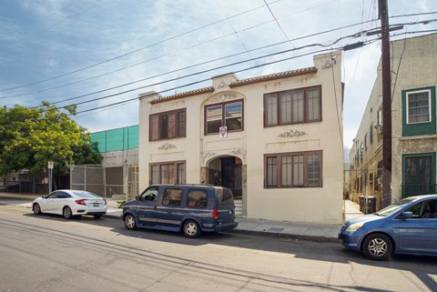 A blue van is parked in front of a building.