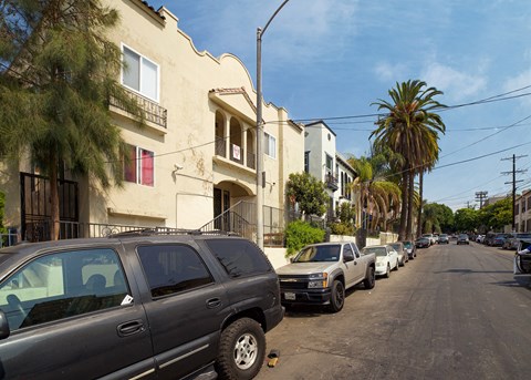 A street lined with parked cars and houses.