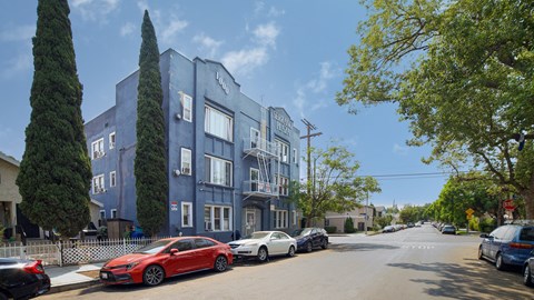 A red car is parked on the side of a street.