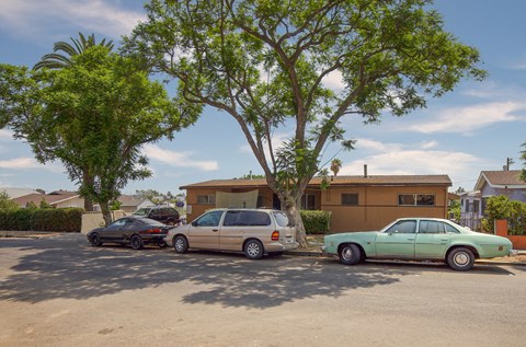 Three cars parked in a driveway in front of a house.