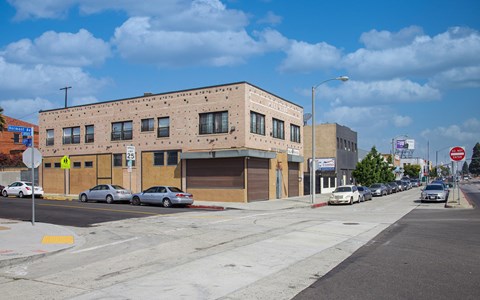 A street view of a building with cars parked in front.