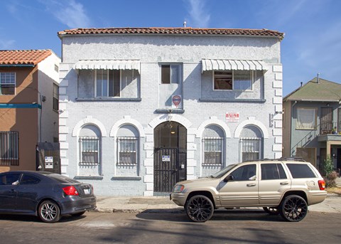 A white building with a black gate in front.