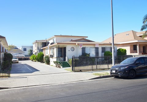 A black car is parked on the right side of a street.