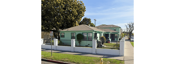 a green house with a white fence