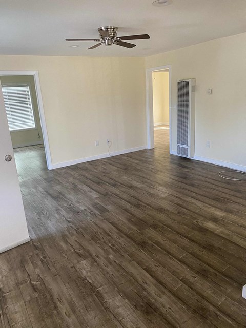 A room with wooden flooring and a ceiling fan.
