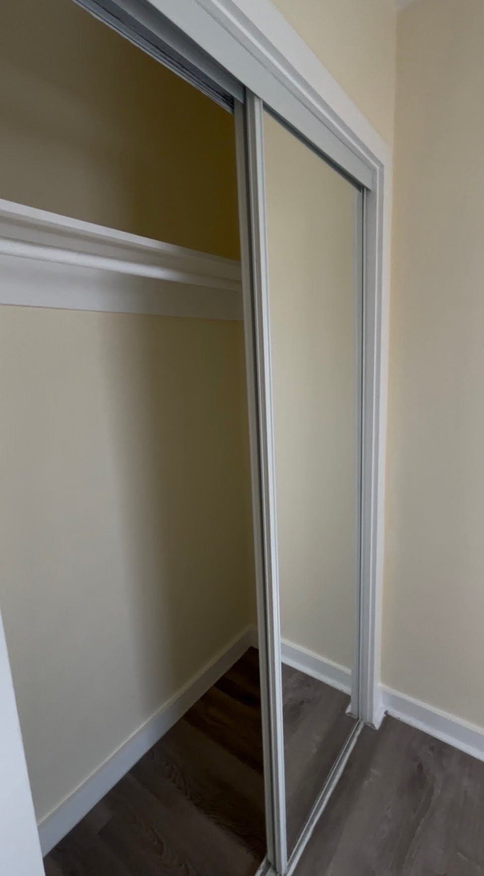 A sliding door in a room with a white wall.