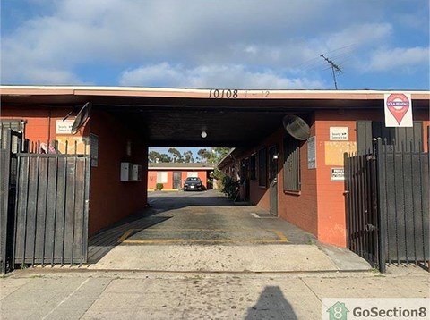 A red building with a black gate in front of it.