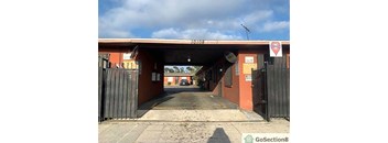A red building with a black gate in front of it.
