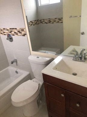 A white toilet sits next to a sink in a bathroom.