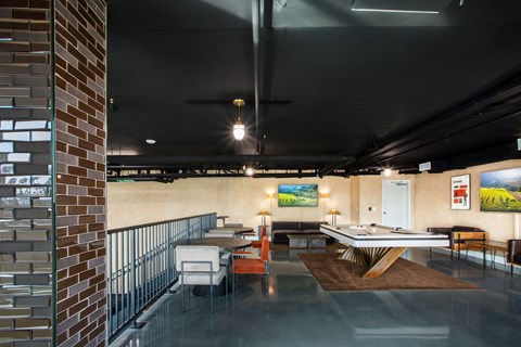 A room with a pool table and a couch.