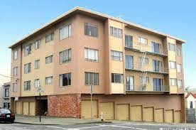 an apartment building with a car parked in front of it
