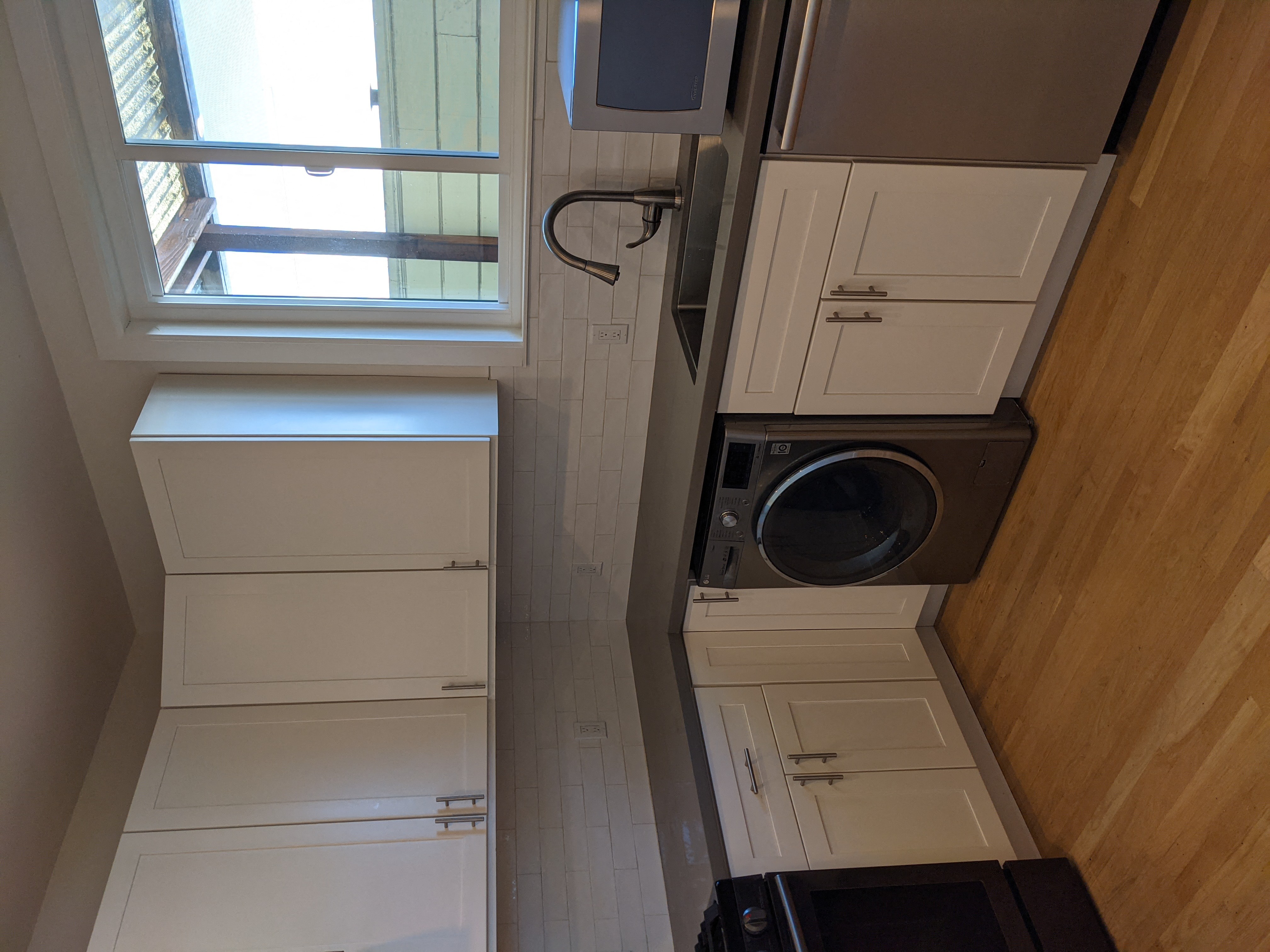 a small laundry room with white cabinets and a washing machine