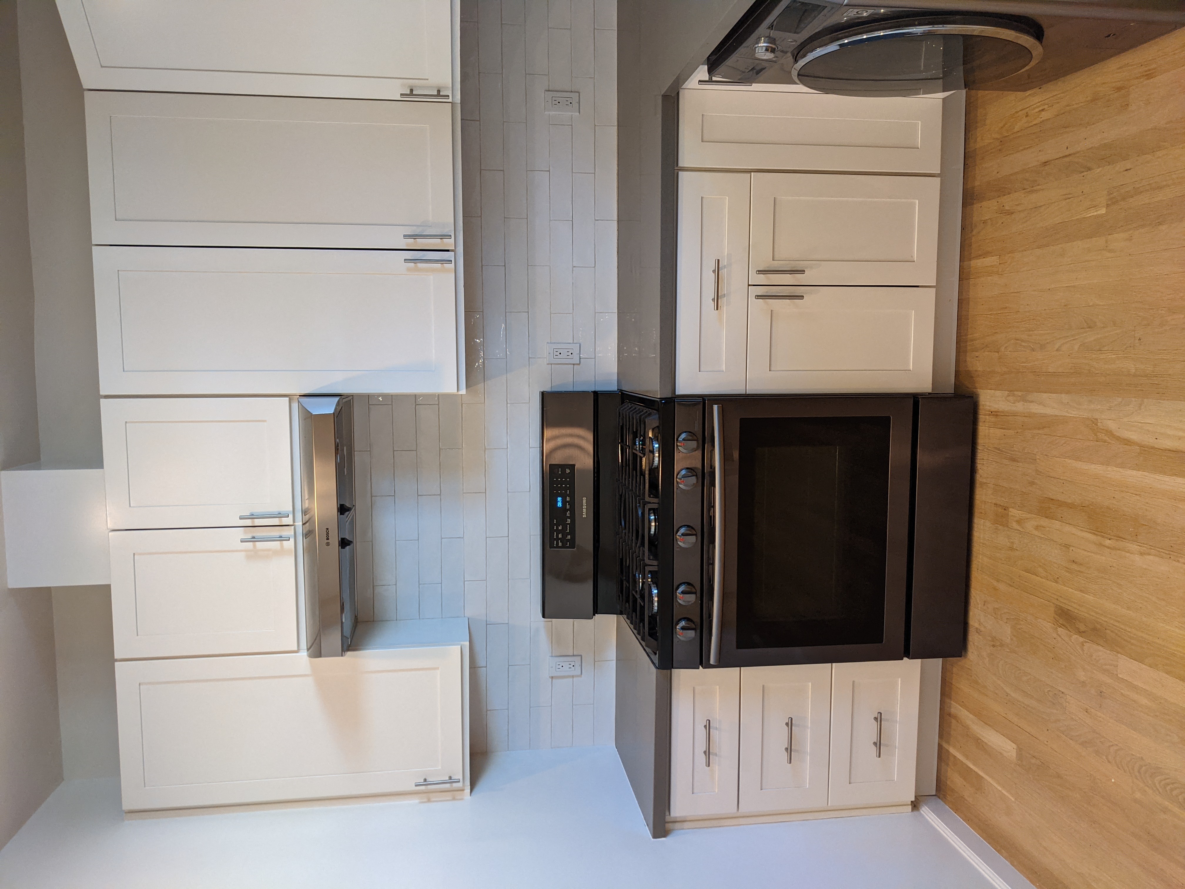a kitchen with white cabinets and a black microwave