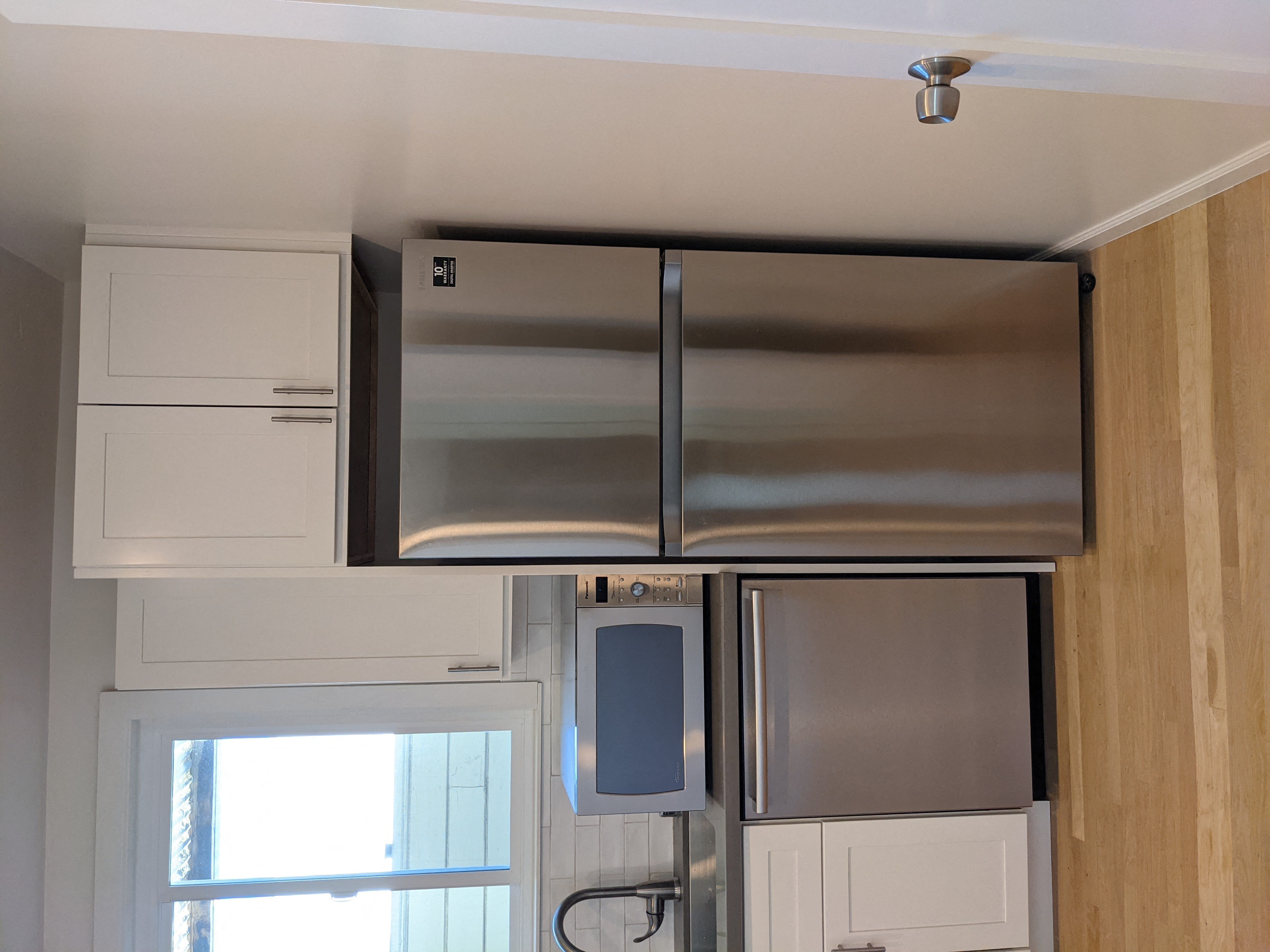 a kitchen with white cabinets and stainless steel appliances