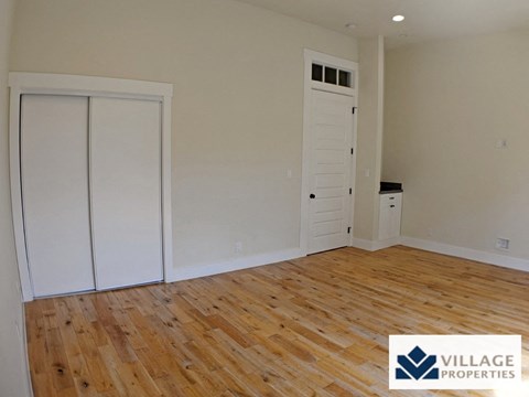 the living room of a renovated house with wood floors and white closets