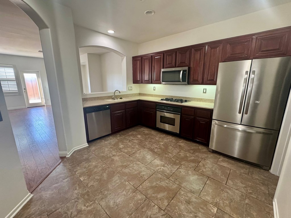 A kitchen with brown cabinets and a refrigerator.